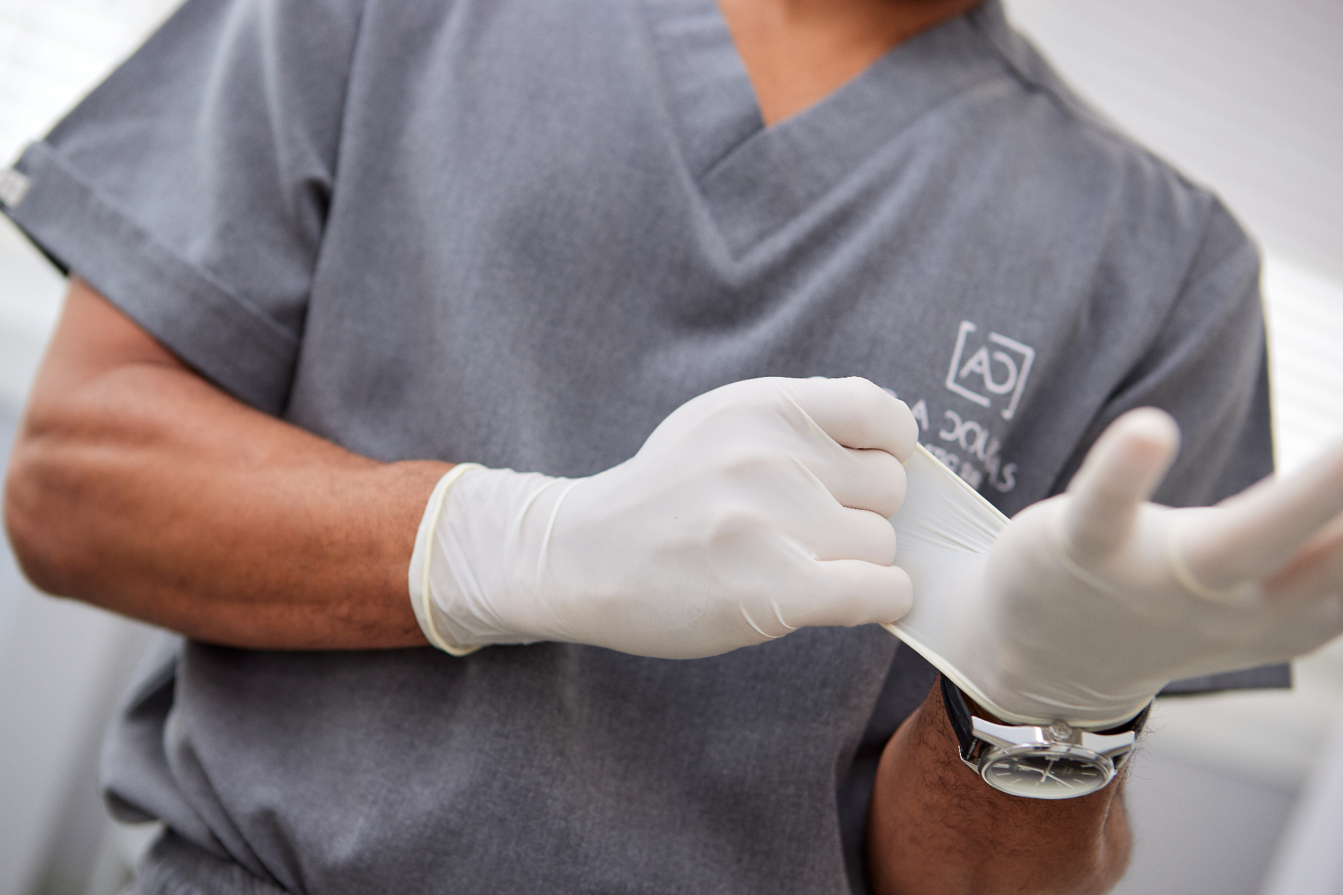 Dr. Arnold Douglas in scrubs preparing surgical gloves